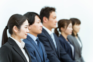 椅子に座った企業・会社の従業員・スタッフ・正社員・スーツ姿の男女の（ビジネスマン・ビジネスウーマン）
