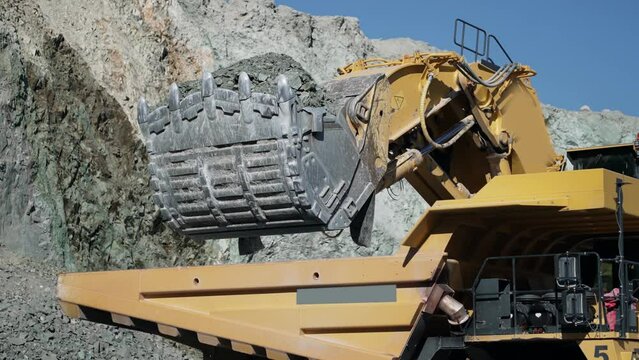 Industrial dumper trucks and wheel loader bulldozer working on open mine pit, slow motion