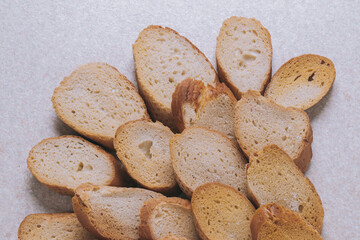 Delicious croutons. Pieces of roasted white bread. Sliced bread on a table, top view.