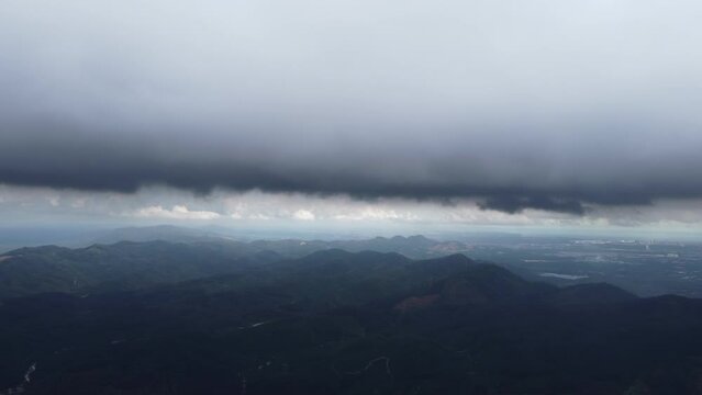 Aerial view ascending toward dark raining cloud