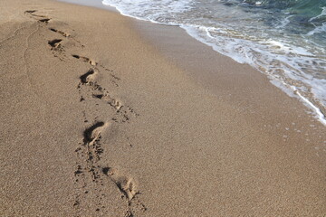 Footprints in the sand on the mediterranean sea