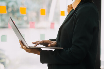 Entrepreneur Asian businessman and businesswoman discussing new business project in tablet in modern Meeting In Modern Office, Asian business casual concept.