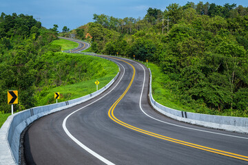Long curvy forest asphalt road over the hills. Beautiful curved road in the forest. Side view of...