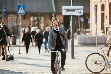 Mature man cycling in the city while commuting to work