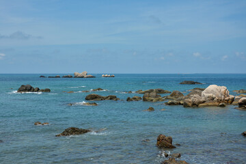 Fototapeta na wymiar rocks on the blue sea under blue sky in sunny day