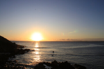 sunset landscape on the beach, nature, blue sea, colors yellow, orange, red, blue and purples, waves, clouds and stones
