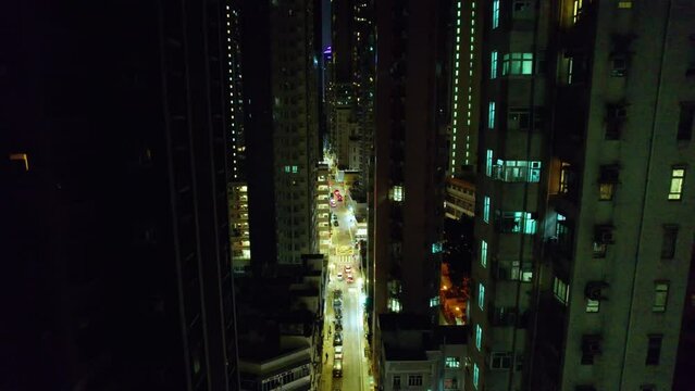 Vol au dessus de la ville de Hong Kong, China, Asie  au milieu des b&acirc;timents et gratte-ciel et au-dessus des tours immenses et de rues illumin&eacute;es pendant la nuit.
