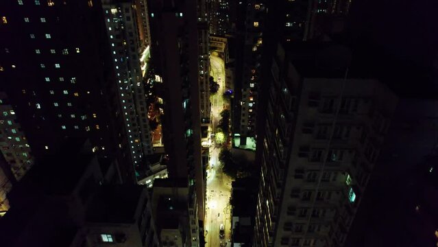 Vol au dessus de la ville de Hong Kong, China, Asie  au milieu des b&acirc;timents et gratte-ciel et au-dessus des tours immenses et de rues illumin&eacute;es pendant la nuit.