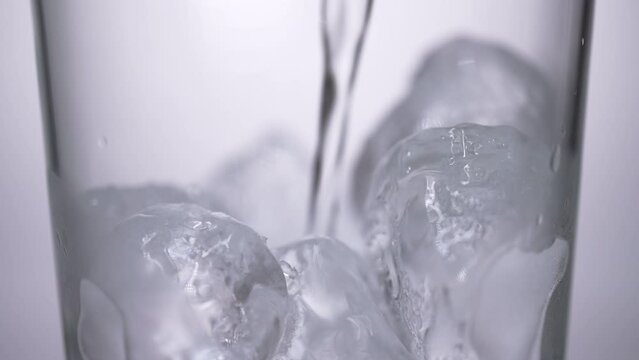 氷の入ったグラスに炭酸水を注ぐスローモーション動画