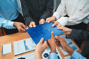 Corporate officer worker collaborate in office, connecting puzzle pieces with report paper on table...