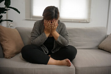 Sad Young woman. Young woman at home living room sofa feeling sad tired.Young woman depressed emotion panic attacks.