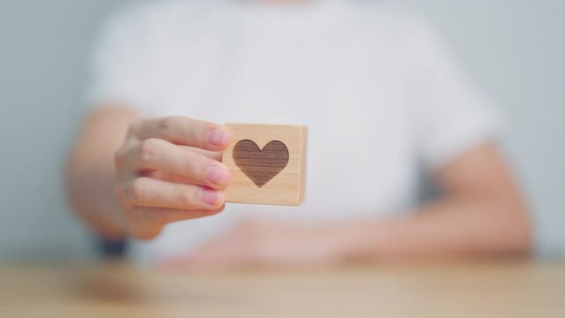 Hand holding heart block for health care, love, organ donation, charity, happy family, wellbeing and insurance concepts. world heart day, health day and mental health day