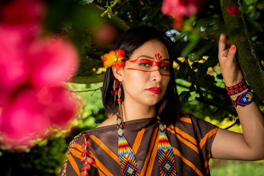 beautiful young peruvian woman of the yanesha culture posing with dresses, jewelry, makeup, clothes and accessories designed with Asháninka iconography in nature