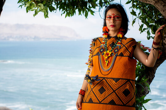 beautiful young peruvian woman of the yanesha culture posing with dresses, jewelry, makeup, clothes and accessories designed with Ash&aacute;ninka iconography in nature
