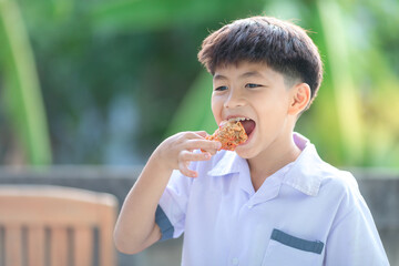 little boy eating fried chicken very delicious face.