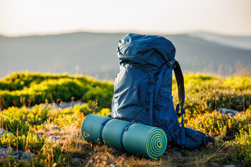 Hiking backpack with mat during trek in mountains. Camping and trekking equipment