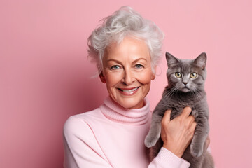 portrait a smiling senior woman with her cat on light pastel pink background. AI Generated
