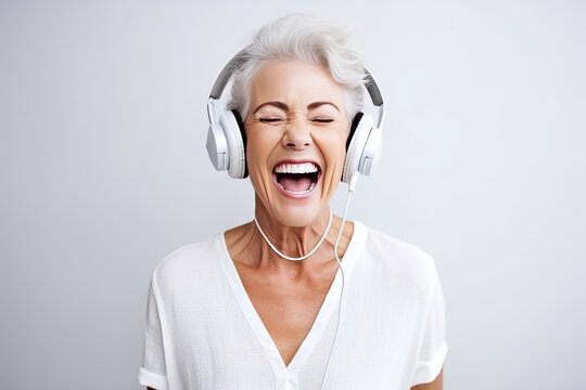 portrait a happy senior woman in wireless headphones dancing, singing in white background . AI Generated