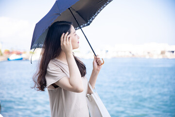 海で日傘を指す女性　A woman pointing at a parasol at the sea © 望菜 竹内