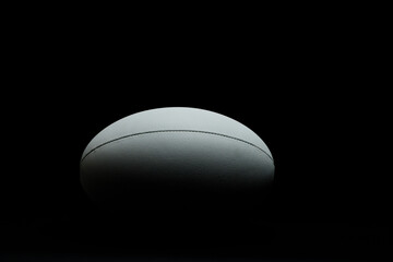 White rugby ball with copy space on black background