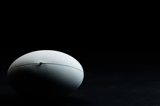 White rugby ball with copy space on black background