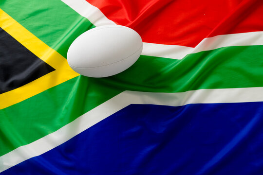White rugby ball over flag of south africa