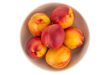 Fresh nectarines fruits in bowl isolated on white background. Ripe peach top view.
