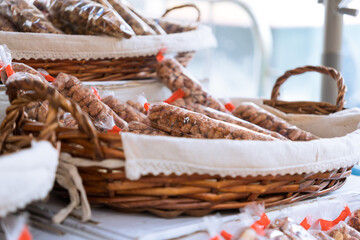 Obraz premium Bags of caramelized almond in a wicker basket. Bagged caramelized nuts.