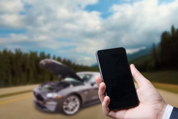 Man use mobile phone, blur image of the car is broken down as background.