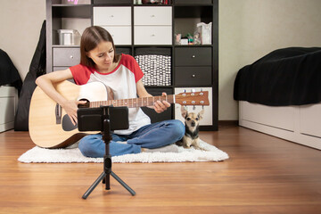 A teen musician, vlogging about her guitar playing and music journey with her smartphone, A...