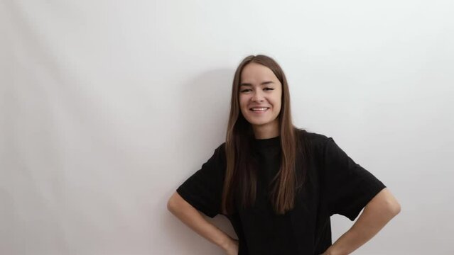 young woman pointing at a place for text,a portrait of a cheerful teenager on a white background, a student in casual clothes smiling