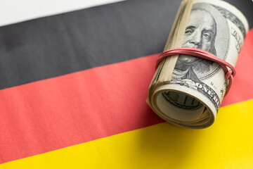 Pile of dollars against digitally generated german national flag