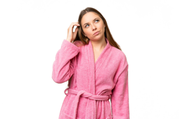 Young woman in a bathrobe over isolated chroma key background having doubts and with confuse face expression