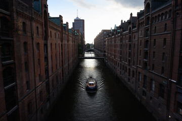 Naklejka premium Boat on the Kehrwiederfleet Canal in the Speicherstadt Warehouse District of Hamburg