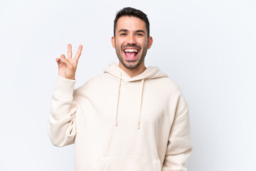 Fototapeta premium Young caucasian man isolated on white background smiling and showing victory sign
