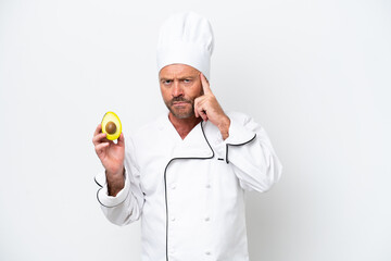 Chef man holding an avocado isolated on white background thinking an idea