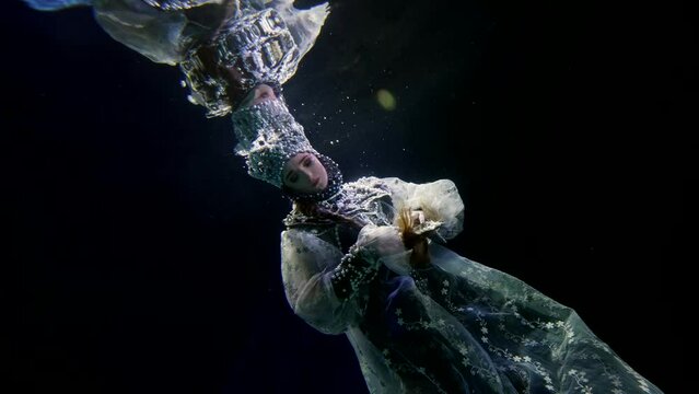 graceful princess in underwater world, enigmatic female figure in dark water of magic sea