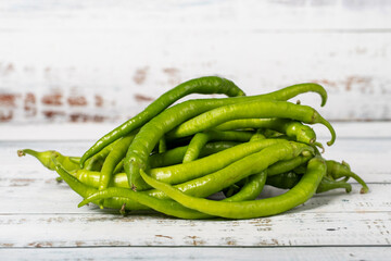 Green pepper on a white wood background. Fresh raw green chili pepper harvest season concept. Vegetables for a healthy diet