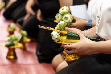 Hand holding gold tray with cone craft lotus flower revered to senior people and ask for blessing in the teachers' day observation. 