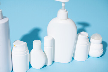 Still life with white blank clean jar and bottle with beauty cosmetic product, isolated on blue color background. Mockup
