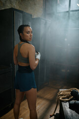 Healthy strong female boxer portrait over old vintage locker room at gym