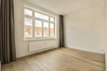 an empty room with wood flooring and large windows looking out onto the street in front of the...