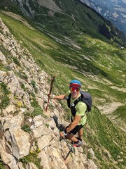 Obraz premium Young Man runs over the Hardergrat above Lake Brienz. Mountain mountain ridge extreme trail running in switzerland. High quality photo