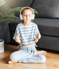 Cute little girl listening to music in headphones