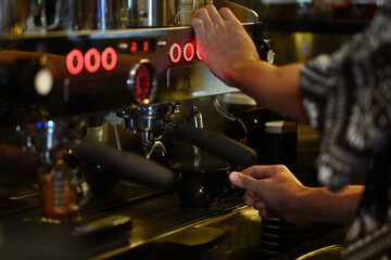 Naklejka premium Professional barista preparing coffee for customer order in modern coffee shop. Small business, startup coffee shop and restaurant