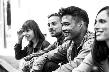 Multicultural people group without smart phone at university college backyard -  Happy millennial friends having fun together sitting at the street - Black and white editing