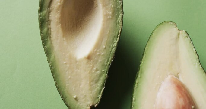 Video of sliced avocado with copy space over green background
