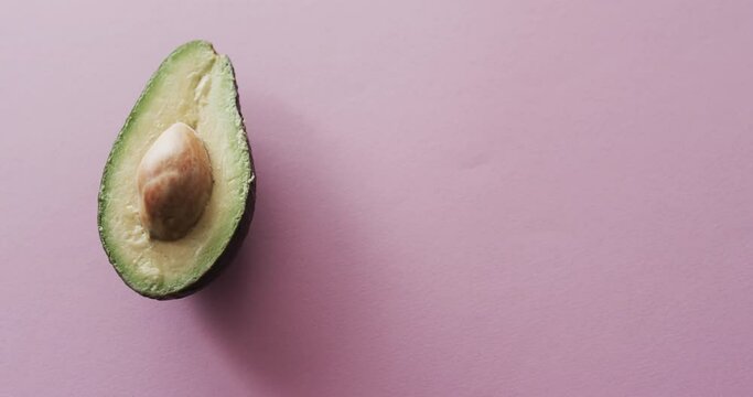 Video of sliced avocado with copy space over pink background