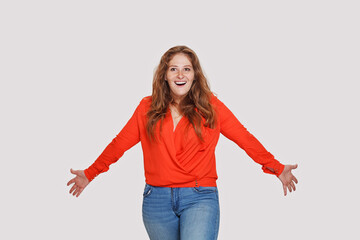 Excited woman with positive facial expression standing on white background, studio portrait