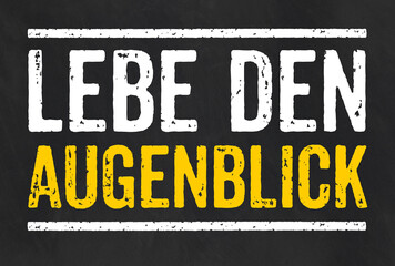 Fototapeta premium Tafel mit dem Text Lebe den Augenblick